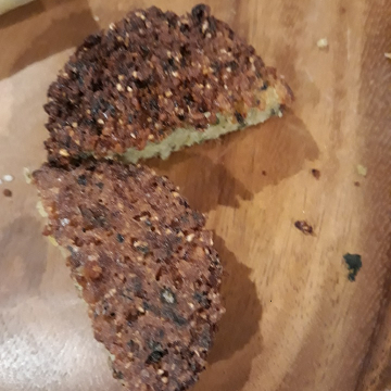 A falafel, cut into two pieces, sitting on a wooden surface